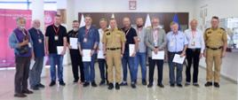 Pamiątkowe zdjęcie grupowe uczestników szkolenia z zakresu ochrony przeciwpożarowej dla rzeczoznawców (11 osób) w towarzystwie Zastępcy Komendanta Centralnej Szkoły PSP oraz oficera CS PSP
