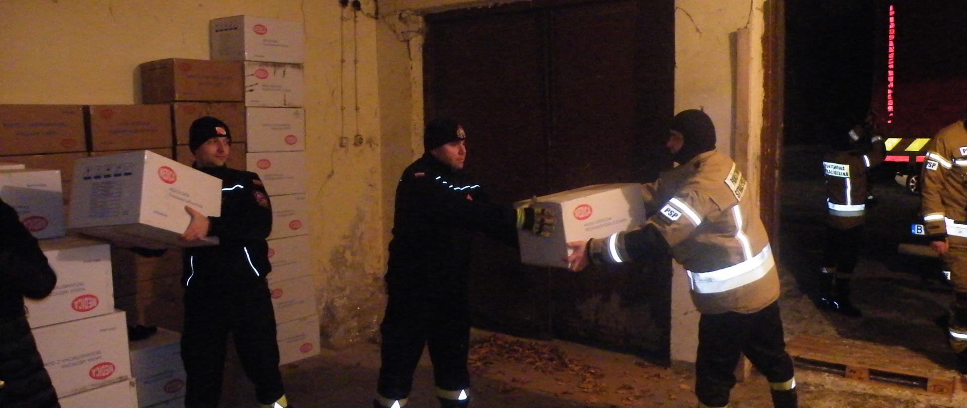 Zdjęcie przedstawia rozładunek maseczek przez strażaków KP PSP w Siemiatyczach.