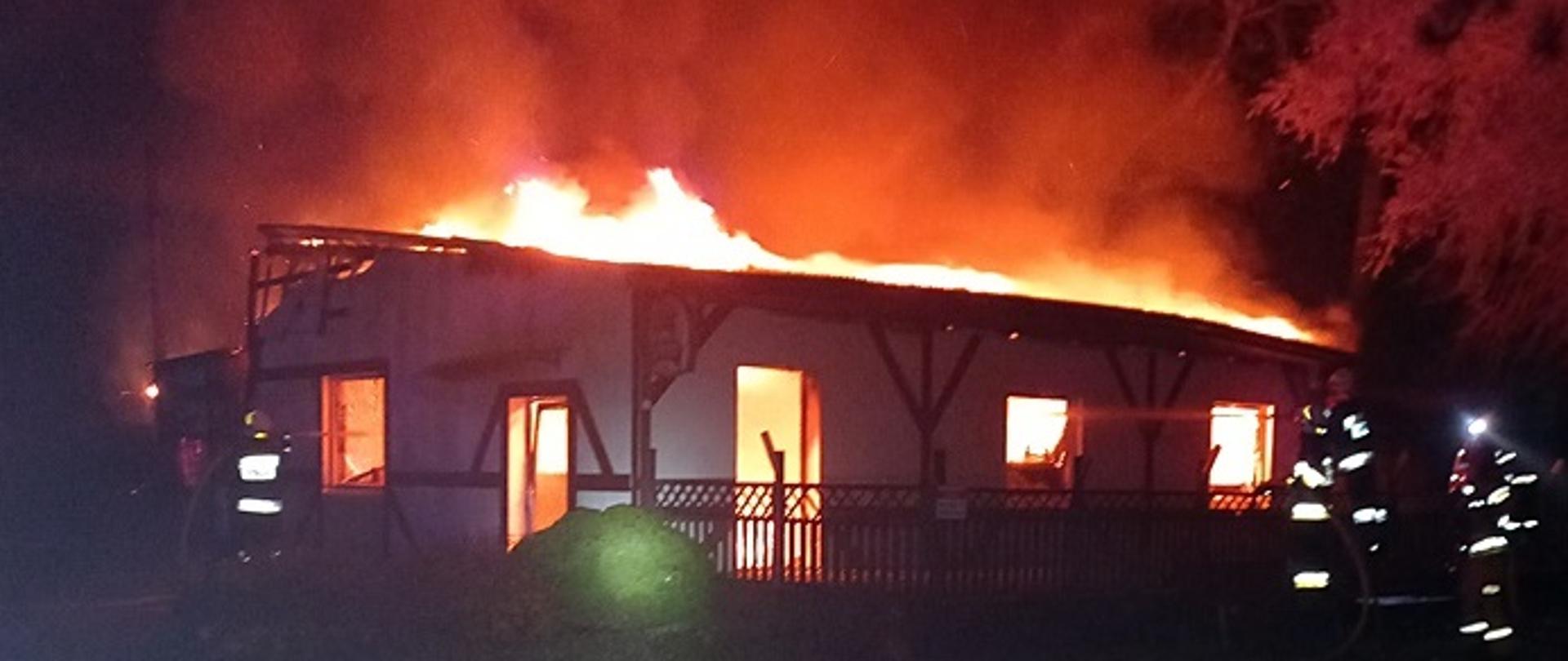 Widać budynek restauracji cały objęty ogniem, jest noc