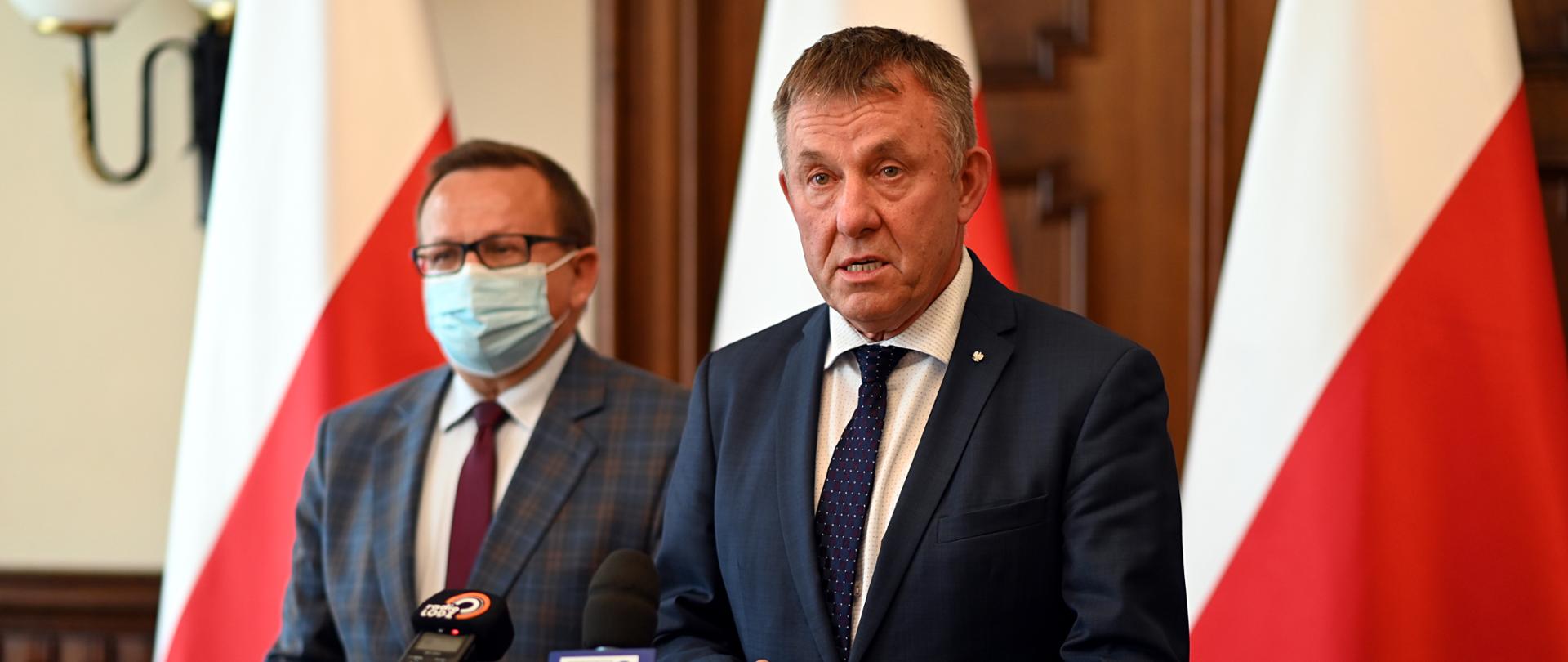 Wicewojewoda łódzki Karol Młynarczyk przemawia przed mównicą na konferencji prasowej w Łódzkim Urzędzie Wojewódzkim