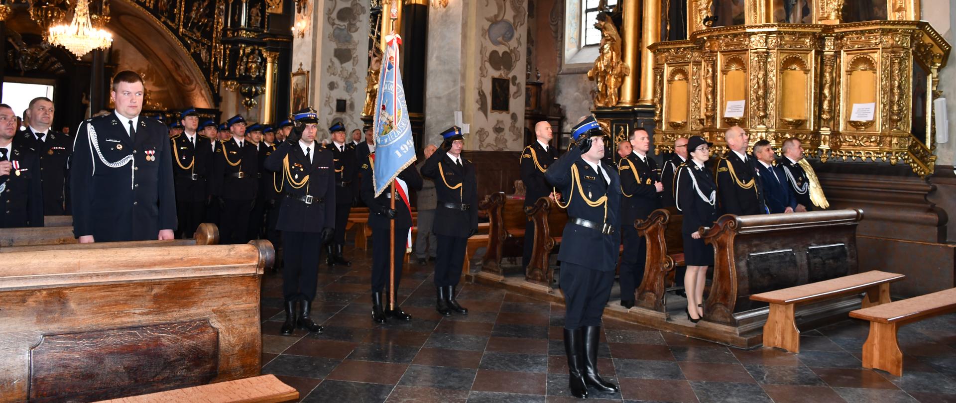 Na zdjęciu widzimy kompanie reprezentacyjną straży pożarnej stojącą na baczność. W tle wnętrz Bazyliki Ojców Bernardynów w Leżajsku.