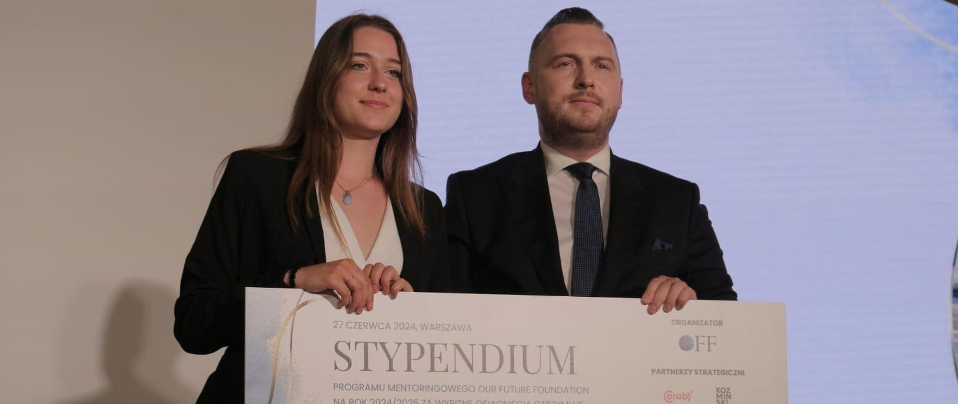 Wiceminister Konrad Wojnarowski na Gali Stypendialnej Our Future Foundation wręcza stypendium pani Agacie Kalińskiej