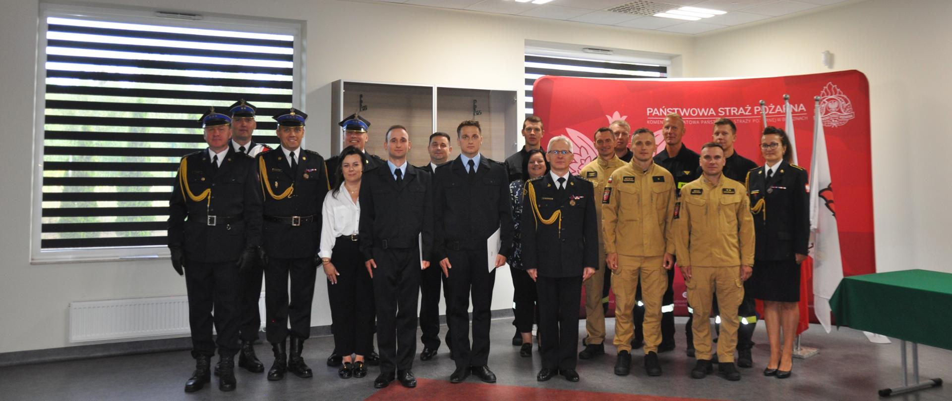 Grupowe zdjęcie funkcjonariuszy komendy i pracowników cywilnych, którzy uczestniczyli w uroczystości ślubowania strażaka Damiana Pązika i strażaka Mateusza Olczyka.