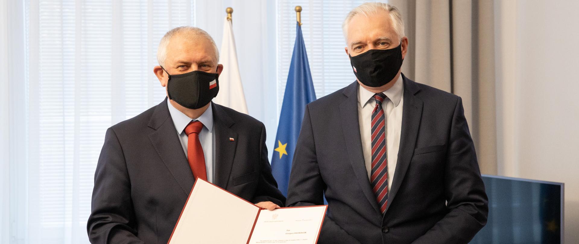 Wicepremier Jarosław Gowin wręcza Grzegorzowi Piechowiakowi akt nominacji na funkcję wiceministra rozwoju, pracy i technologii 