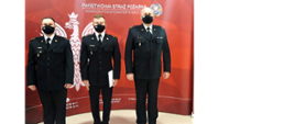 Zdjęcie przedstawia od prawej komendanta powiatowego, nowego zastępcę dowódcy zmiany, dowódce jednostki ratowniczo gaśniczej na czerwony tle z białym orłem w koronie i logo PSP