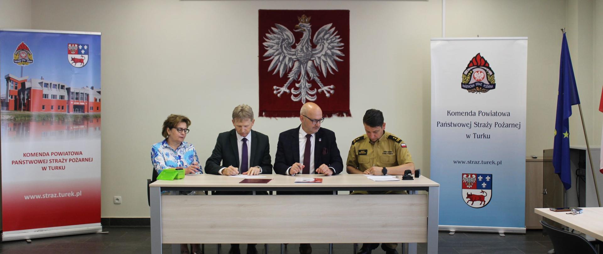 Komendant Powiatowy wraz w przedstawicielami Starostwa powiatowego w trakcie podpisywania umowy.