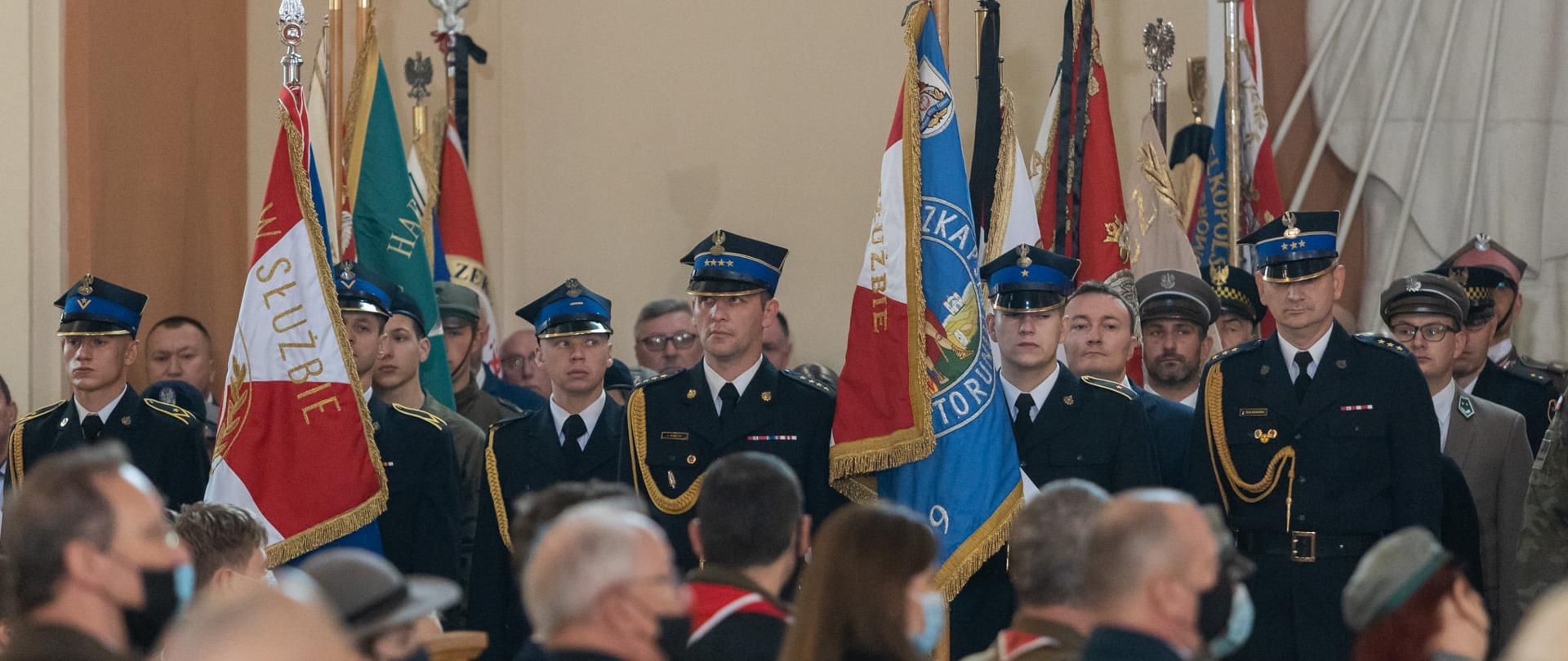 Na zdjęciu poczet sztandarowy Komendy Wojewódzkiej PSP w Toruniu oraz poczet sztandarowy Komendy Miejskiej Państwowej Straży Pożarnej w Bydgoszczy, funkcjonariusze ubrani w mundury wyjściowe PSP. W tle pozostałe poczty stojące wewnątrz Bazyliki