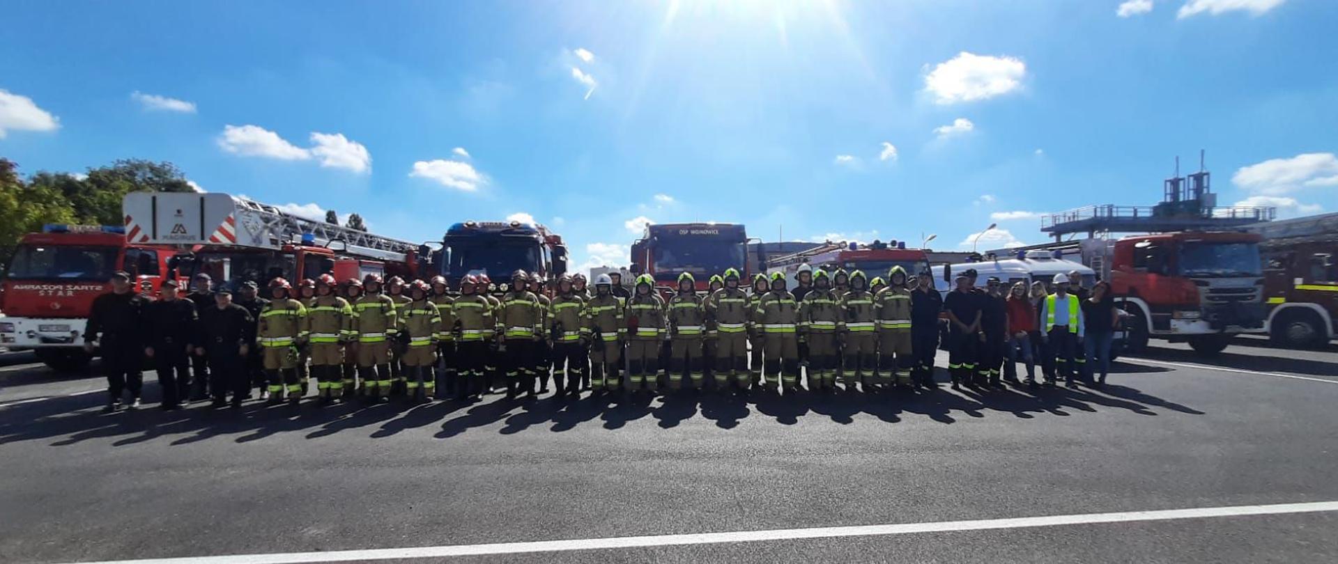 Ćwiczenia Nordzucker Opalenica - zdjęcie grupowe uczestników ćwiczeń na tle samochodów.
