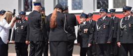 Uroczysty moment dekoracji zasłużonych strażaków. Członkowie jednostki OSP Żeleźniki prężnie prezentują się w ordynkach, odbierając medale i odznaczenia za swoją dotychczasową służbę oraz wkład w rozwój ochrony przeciwpożarowej. Wydarzenie dokumentuje obecna na miejscu fotograf.