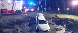 Auto wyciągane ze stawu przez strażaków.