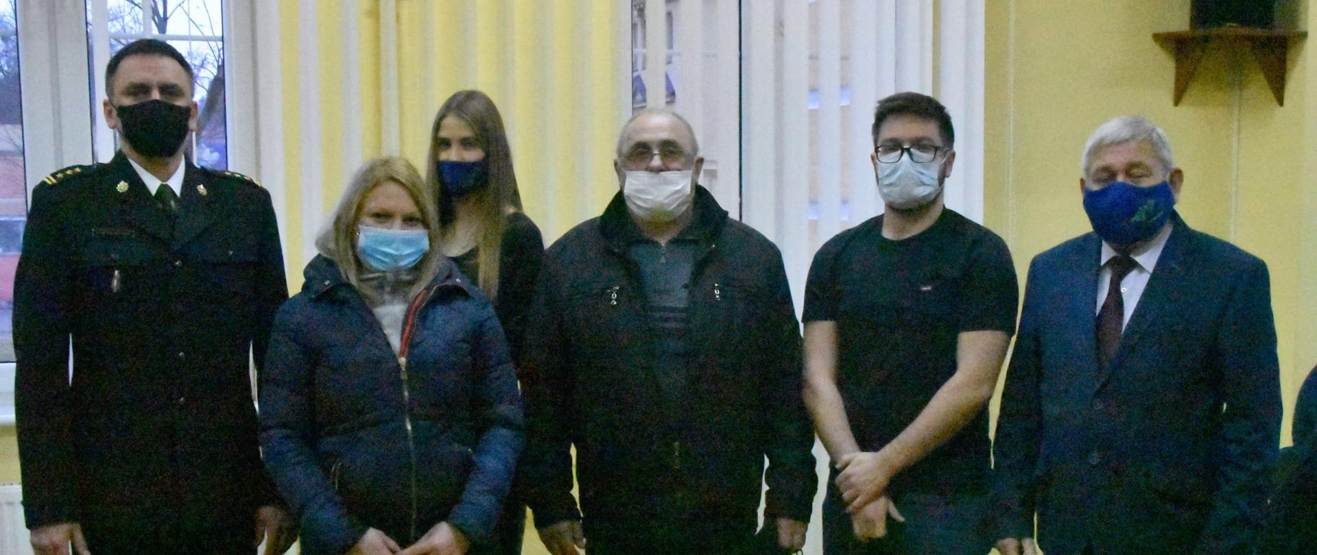 Zdjęcie przedstawia szczęśliwców, którzy wylosowali czujki tlenku węgla oraz dymu. Obok znajduje się Komendant Powiatowy PSP w Lidzbarku Warmińskim oraz Starosta Powiatowy 