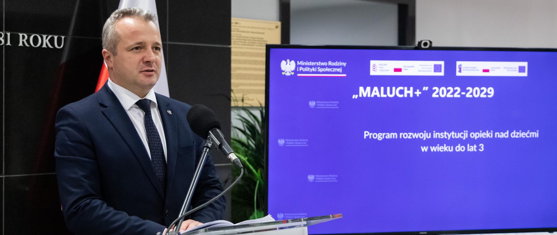 
Grupa osób w garniturach stojących w sali konferencyjnej
