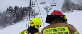 Zdjęcie przedstawia strażaków podczas ćwiczeń z ewakuacji osób z kolei linowej.