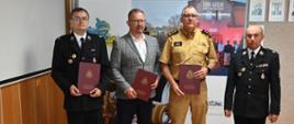 Prezes OSP Godów, Wójt Gminy Godów, Komendant Powiatowy PSP oraz Prezes Zarządu Powiatowego OSP pozują do zdjęcia z podpisanym porozumieniem