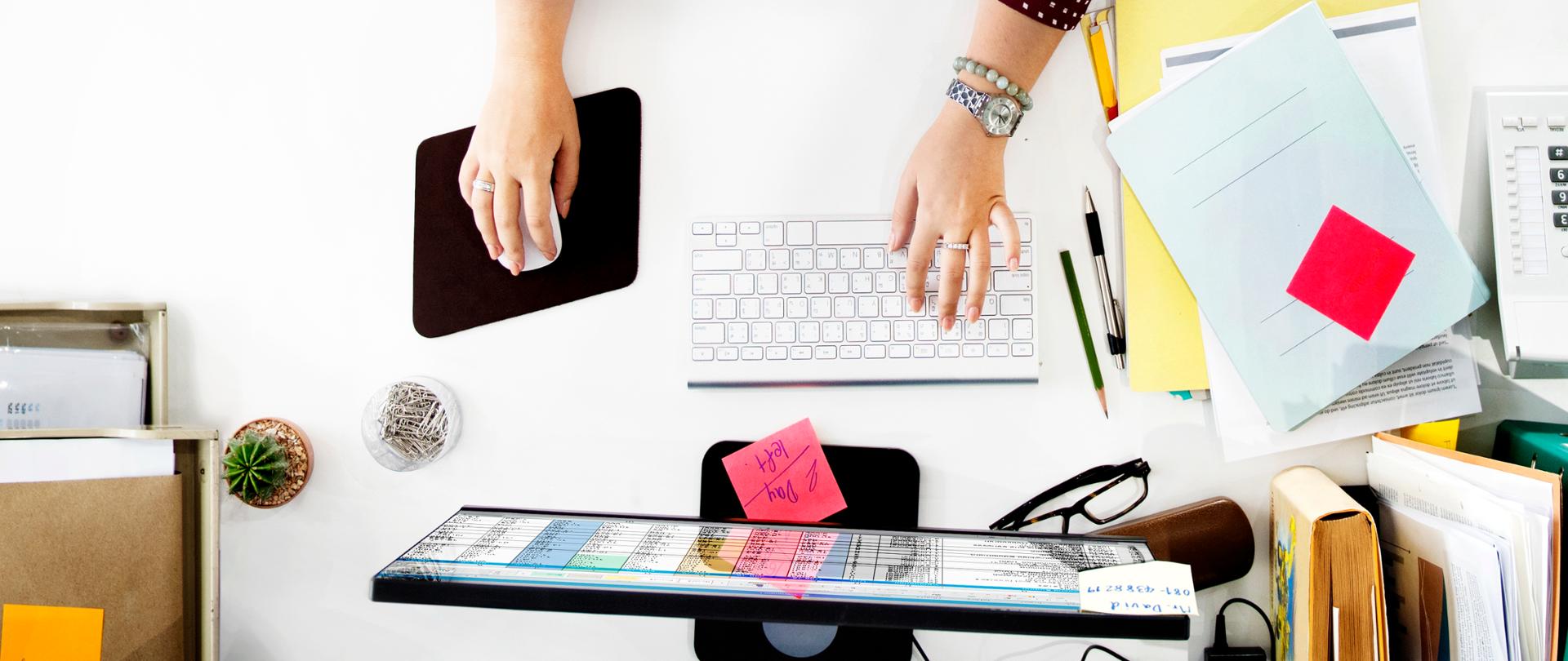 Zdjęcie z góry osoby korzystającej z komputera