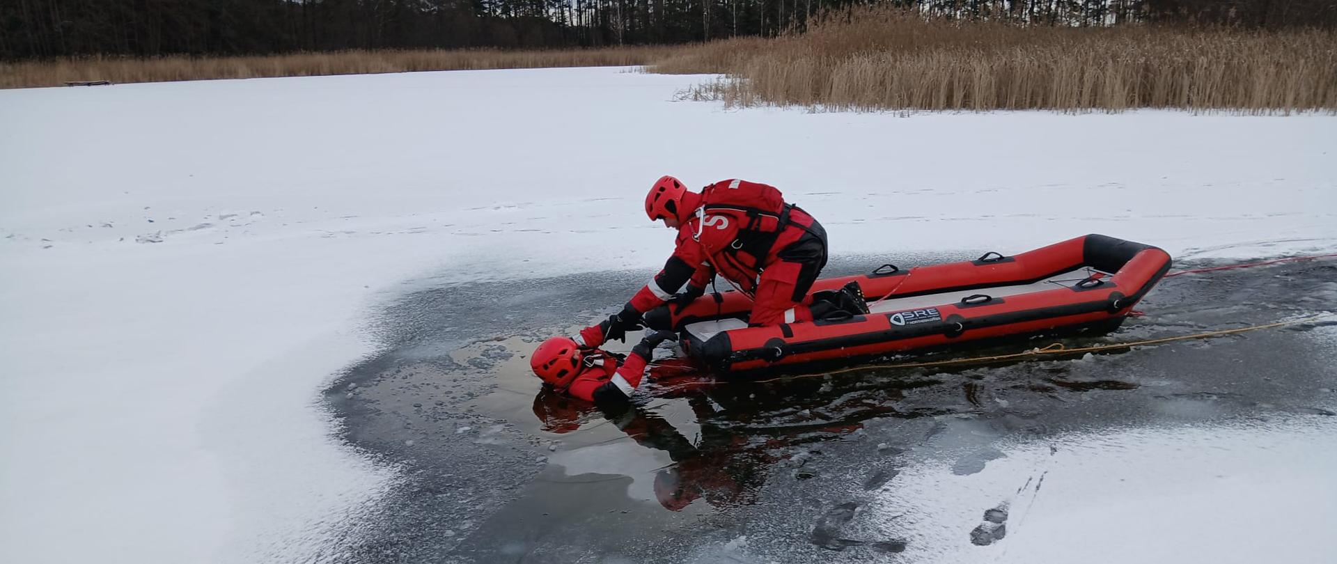Dwóch strażaków podczas ćwiczeń na zamarzniętym jeziorze