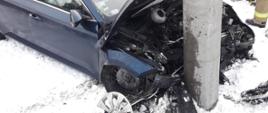 Zniszczony przód samochodu oraz słup w który uderzył samochód.