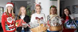 Kilka kobiet w świątecznych strojach trzyma kosze z upominkami
