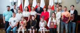Zdjęcie wspólne I wicewojewody łódzkiego Marcina Buchali i nowych obywateli RP