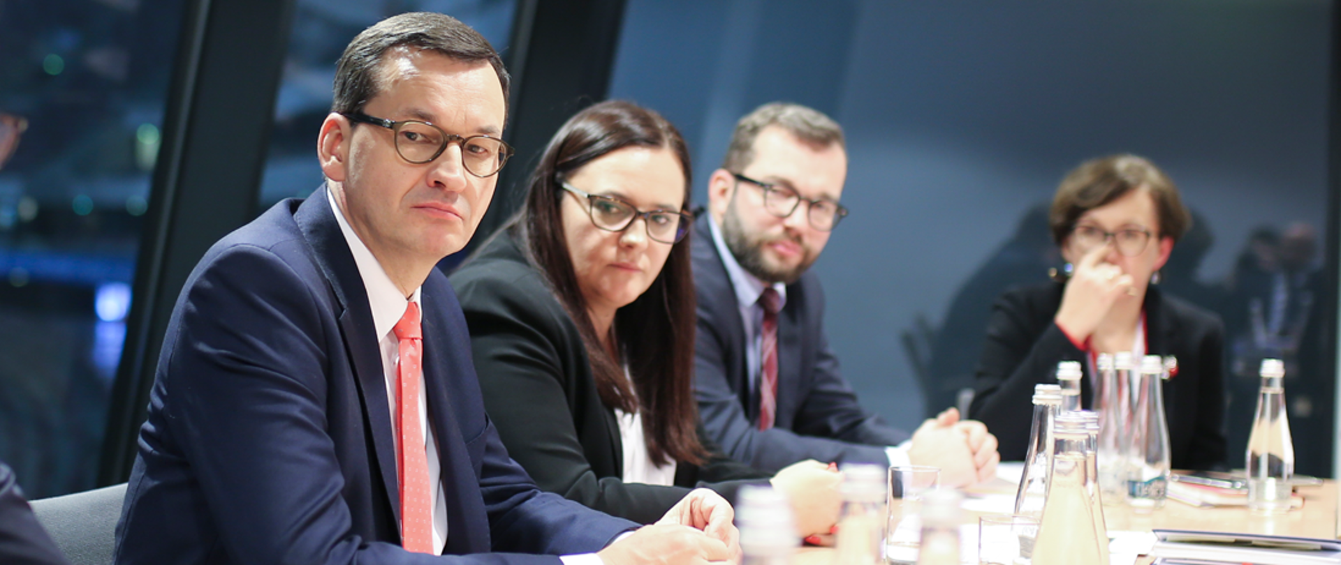 Cztery osoby siedzą przy stole, na którym stoją butelki z wodą i szklanki oraz leżą dokumenty. Od lewej: premier Mateusz Morawicki, minister Małgorzata Jarosińska-Jedynak, wiceminister Grzegorz Puda oraz dyrektor z MFiPR Małgorzata Szczepańska.
