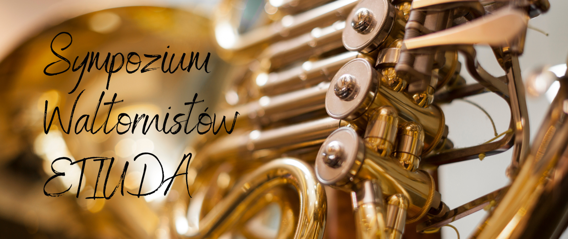Zdjęcie przedstawia zbliżenie na błyszczący, złoty róg (waltornię) z widocznymi zaworami i rurkami instrumentu. Po lewej stronie znajduje się napis w eleganckiej, odręcznej czcionce: „Sympozjum Waltornistów ETIUDA”.