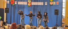 Uczennice na scenie tańczące w strojach cowboyskich przeglądu talentów w PSP 315