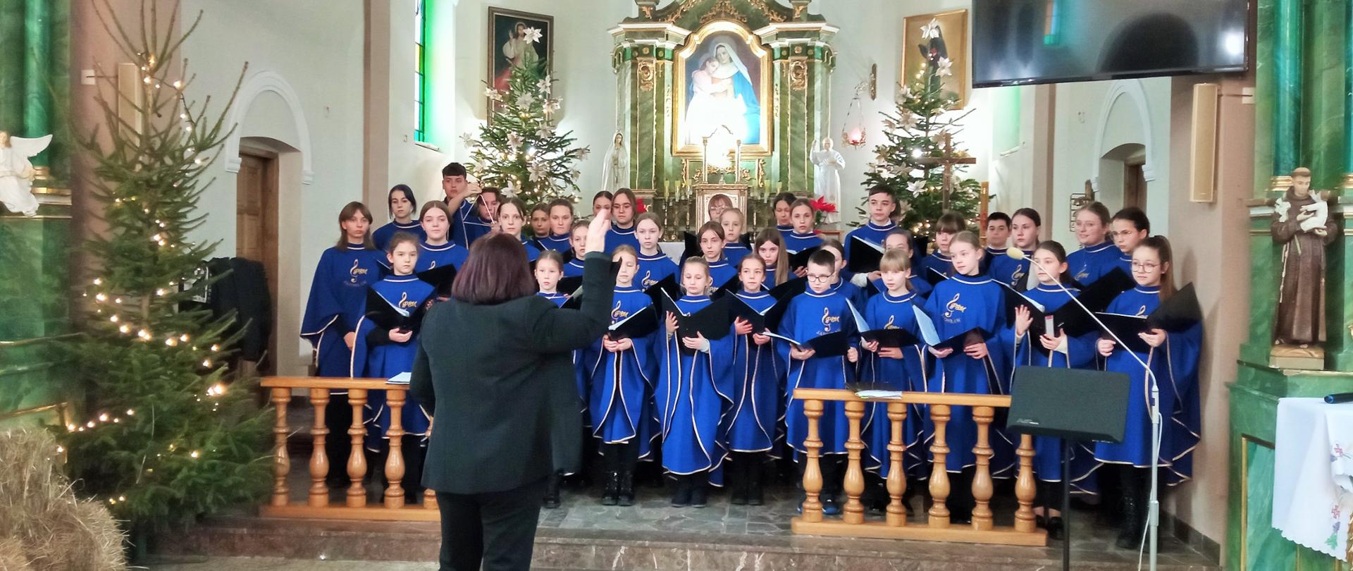 Chór szkolny w jednolitych niebieskich strojach występujący w kościele