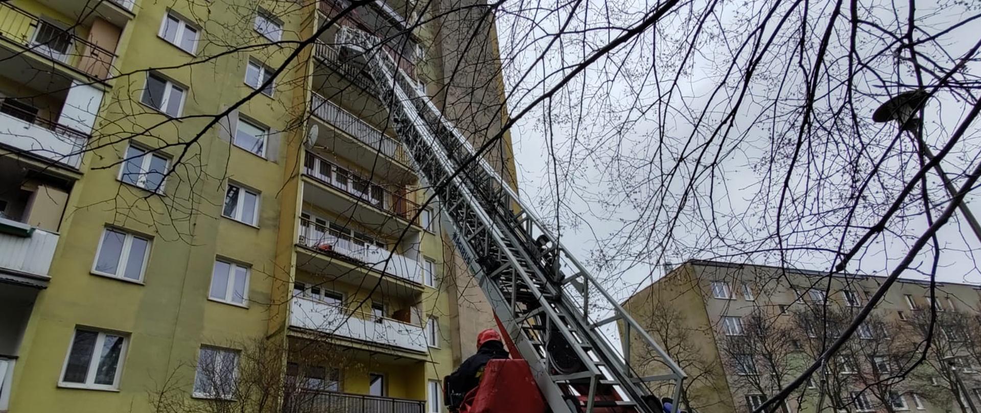 Drabina mechaniczna rozłożona do bloku podczas działań.