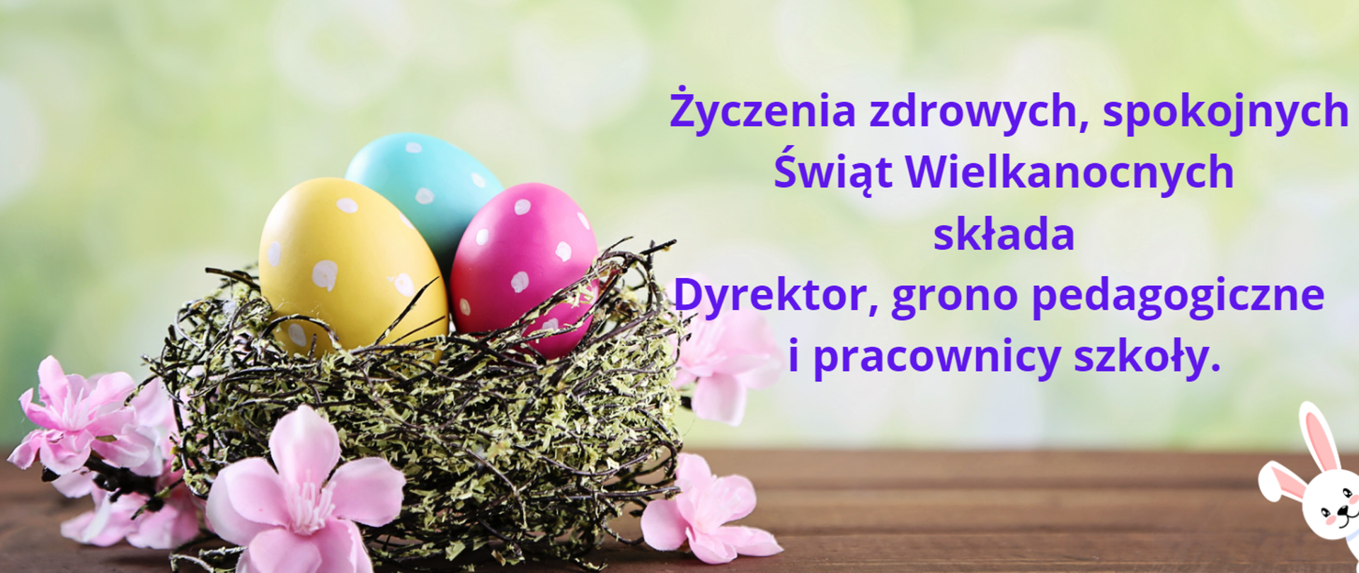 Koszyk z kolorowymi jajkami, ozdobiony kwiatkami. Tekst świątecznych życzeń.

