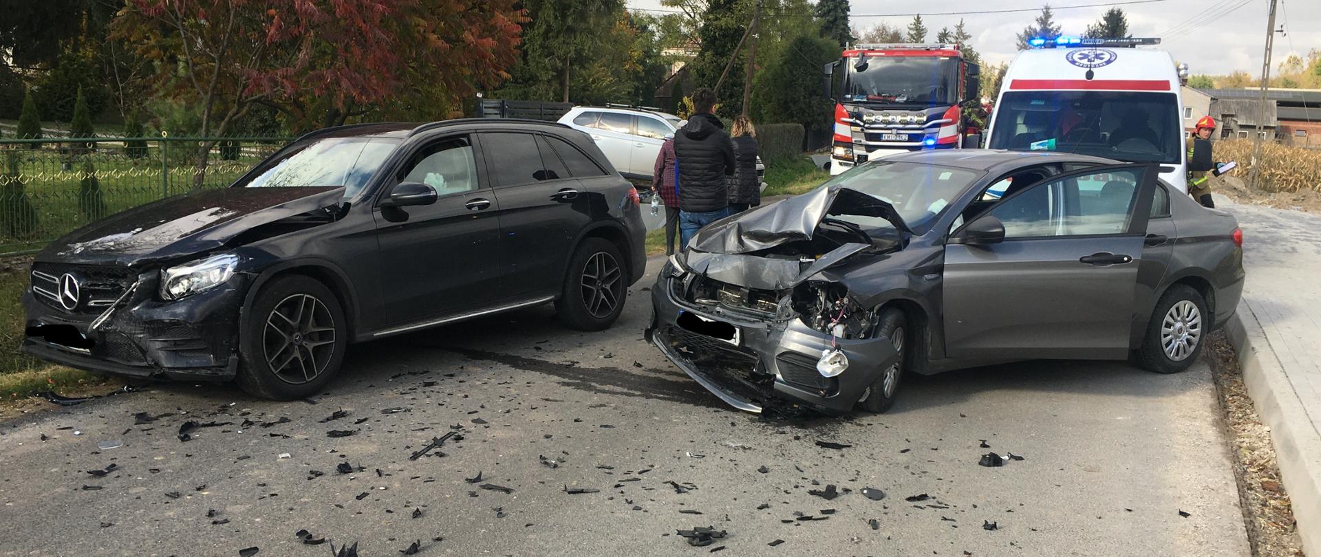 na miejscu widoczne jest jeden samochód PSP, oraz jedna kratka Zespołu Ratownictwa Medycznego w której ratownicy medyczni zabezpieczaj osobę poszkodowaną oraz samochody osobowe ,który znajduje się na jezdni z widocznymi uszkodzeniami karoserii
