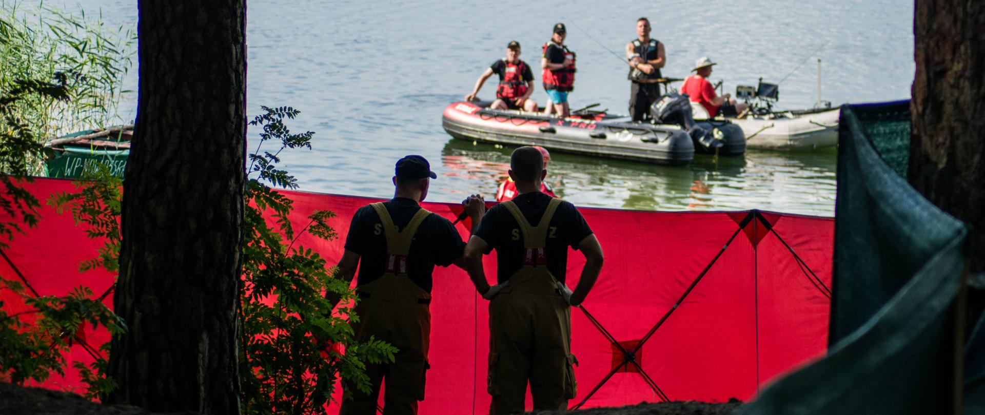 Jezioro, parawan, strażacy na łodzi i na brzegu