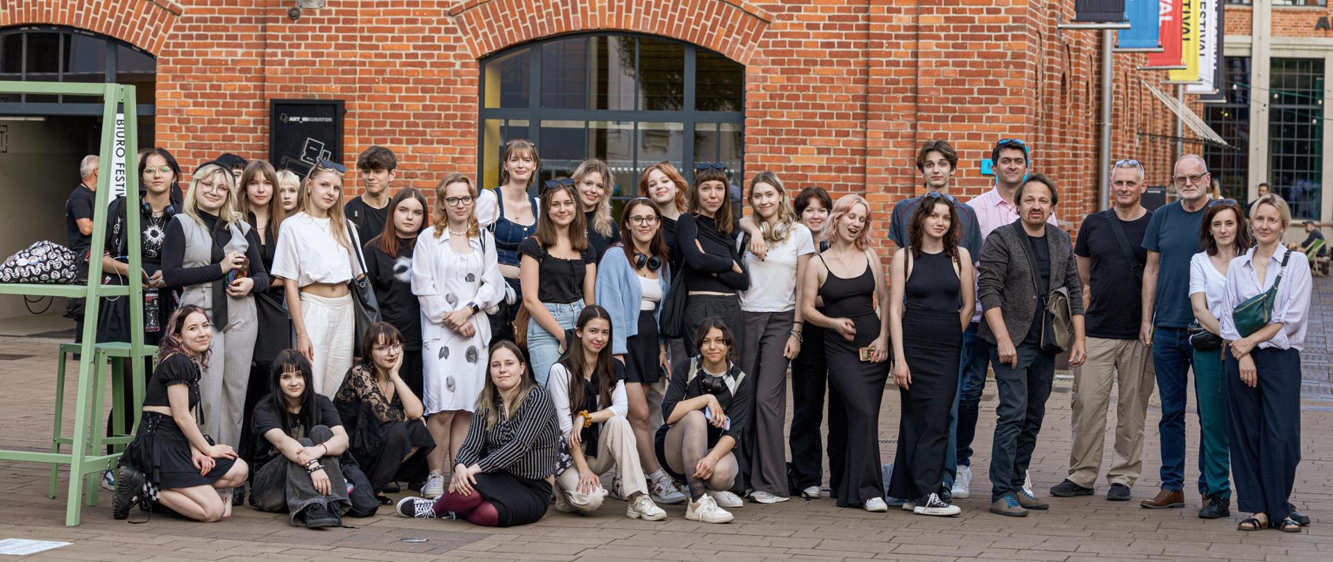 Zdjęcie grupowe uczniów i nauczycieli przed budynkiem Łódź Design Festival
