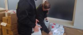 Na zdjęciu widoczni strażacy ochotnicy odbierający środki dezynfekcyjne, maseczki i rękawiczki w celu dostarczenia ich do parafii.