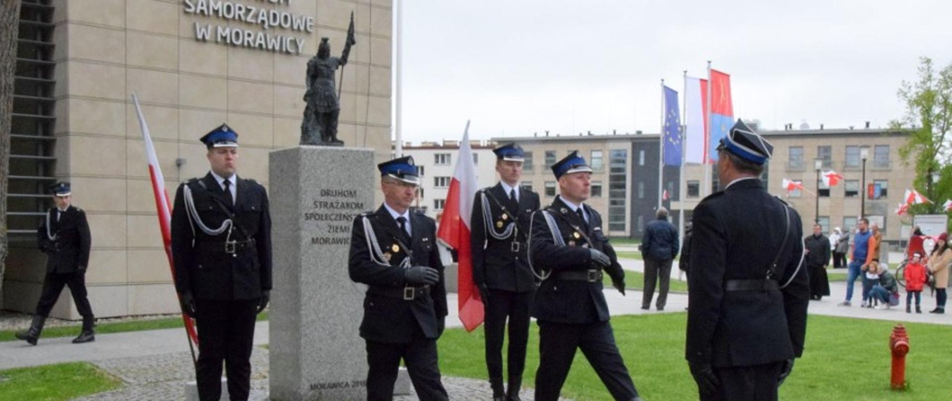 Zdjęcie przedstawia pomnik Świętego Floriana przy którym następuje zmiana warty. 