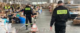 Na zdjęciu strażacy w magazynie z kartonami dla uchodźców