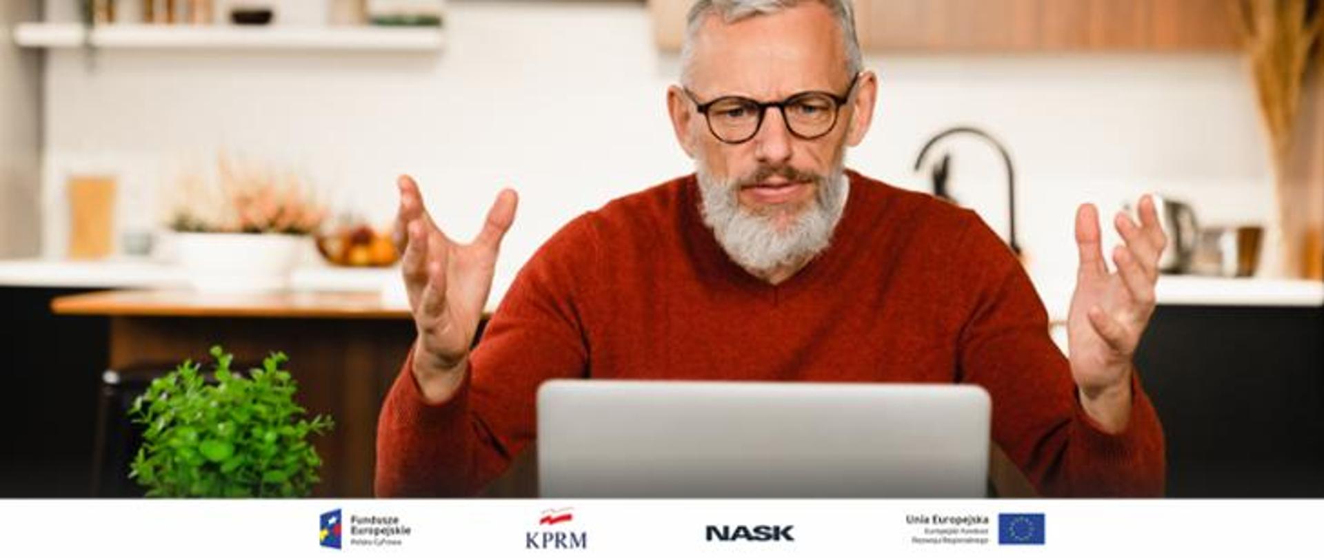Zdjęcie zdziwionego starszego Pana w okularach w czerwonym swetrze przed laptopem z uniesionymi rękami 