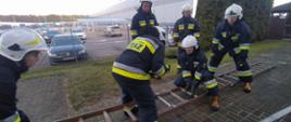 Strażacy podczas łączenia przęseł drabiny