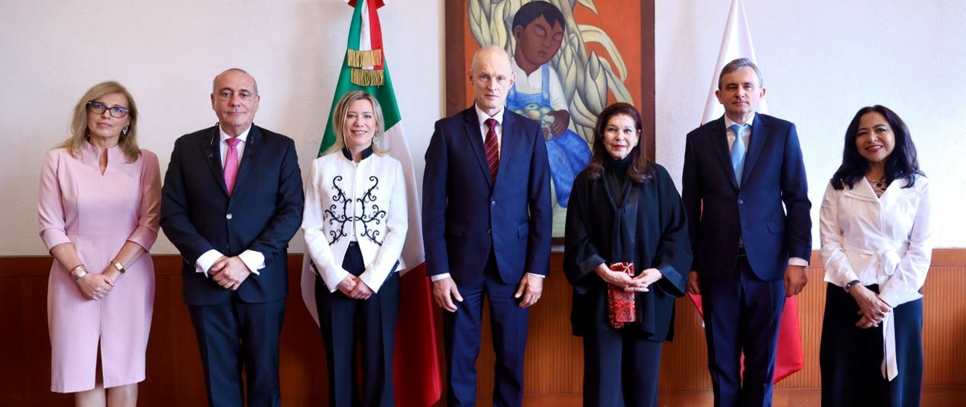 Wiceminister SZ RP W. Zajączkowski, Ambasador RP w Meksyku A. Frydrychowicz-Tekieli, Podsekretarz SZ Meksyku María Teresa Mercado, M. Ziętara i M. Olkowska pozują do oficjalnego zdjęcia na tle flag Polski i Meksyku.