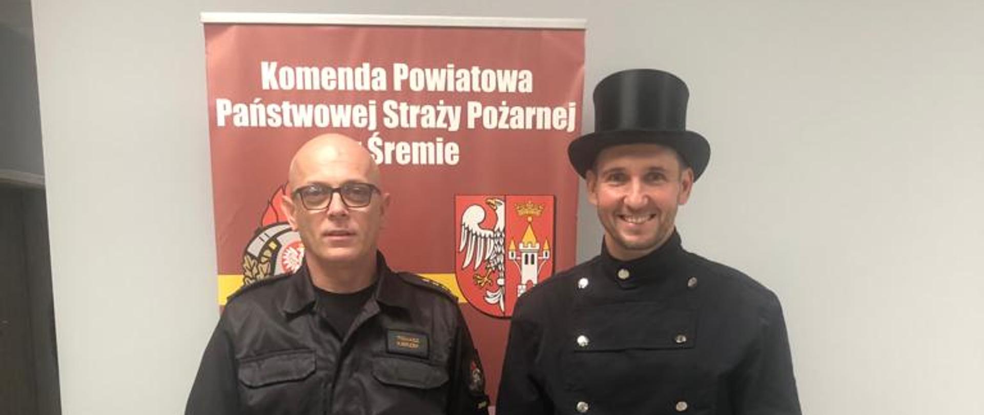 Na zdjęciu Komendant Powiatowy PSP w Śremie z Mistrzem Kominiarskim na tle baneru KP PSP Śrem