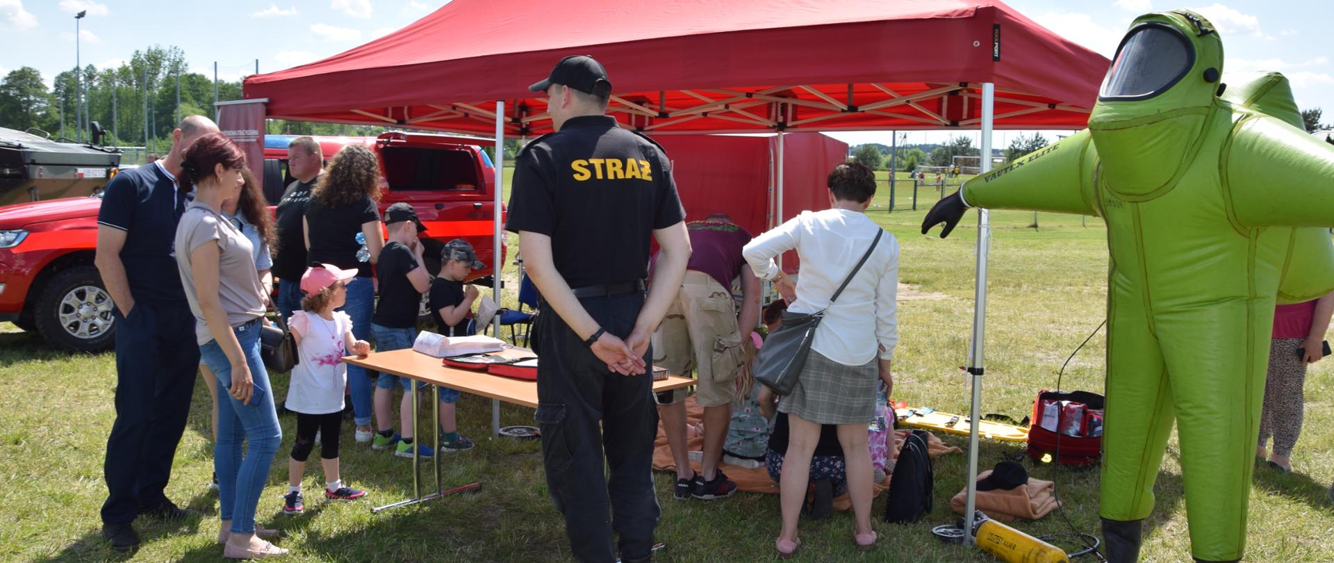 Przedstawiciel PSP przed stanowiskiem tut. Komendy podczas rozmowy z zainteresowanymi