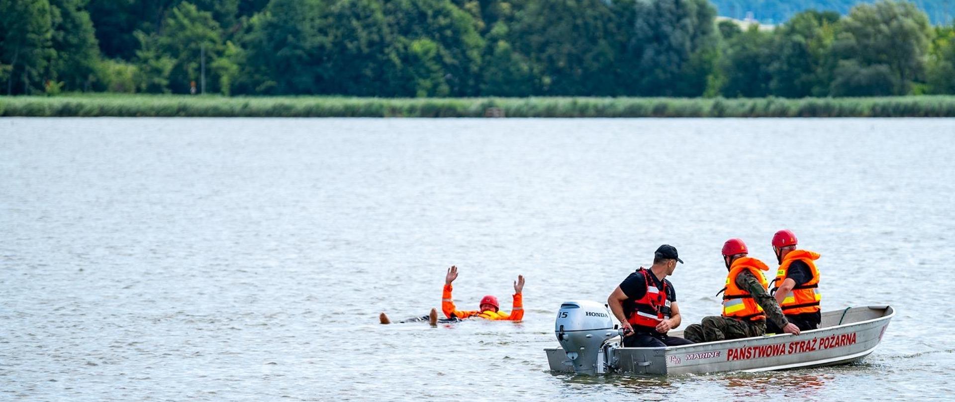 Na zdjęciu ratownicy podpływający do poszkodowanego 