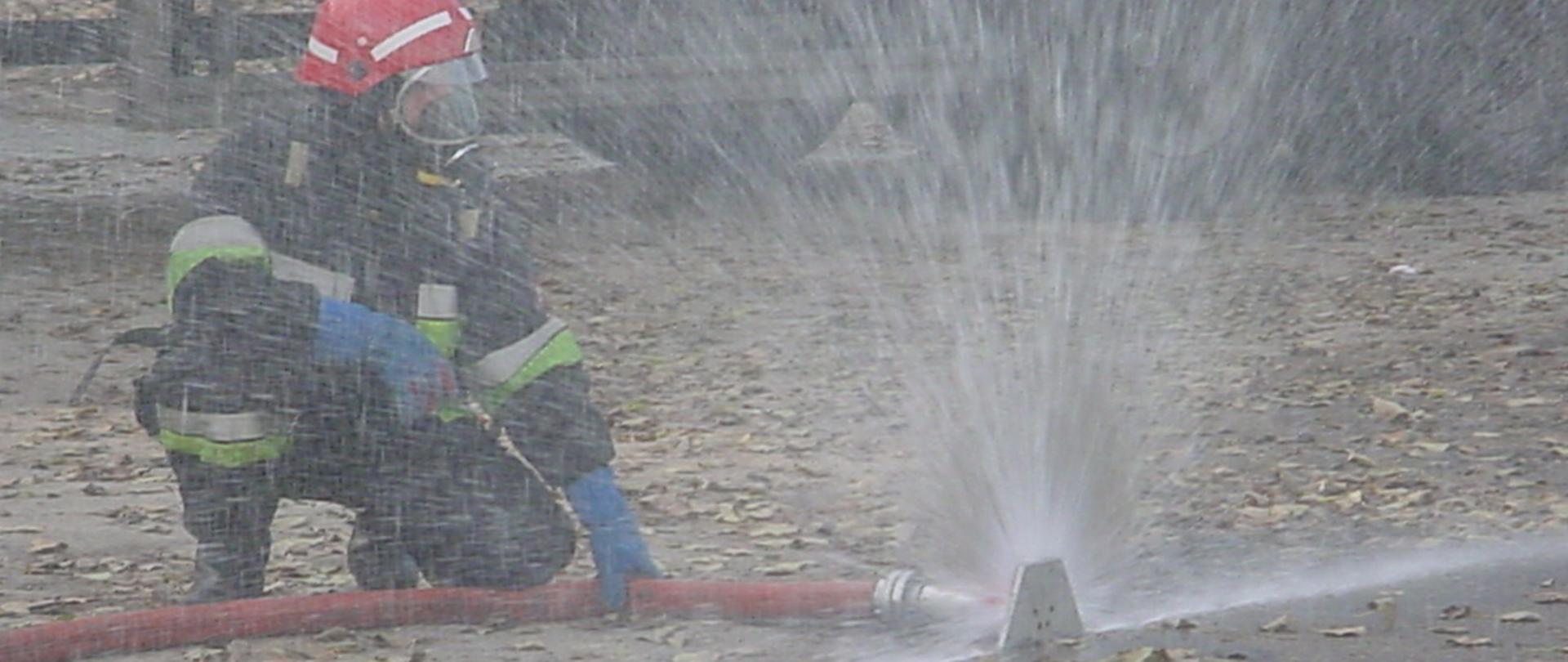 W akcji strażak obsługujący kurtynę wodną