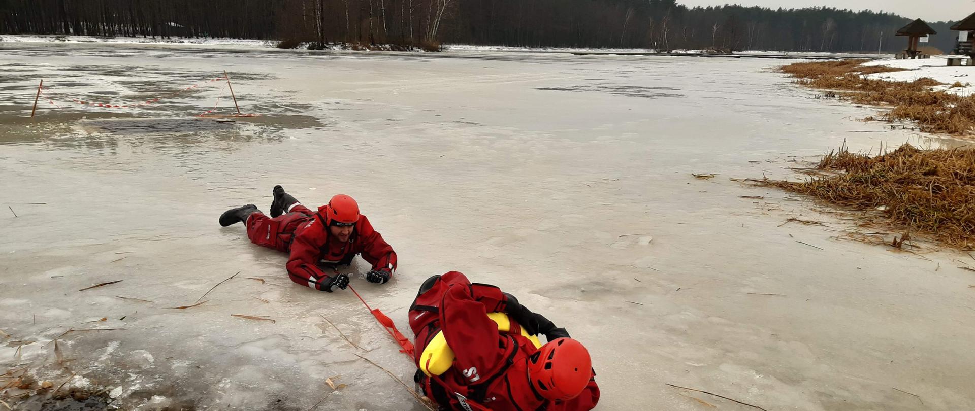 Zdjęcie przedstawia samoratowanie się ratowników, pod którymi załamał się lód
