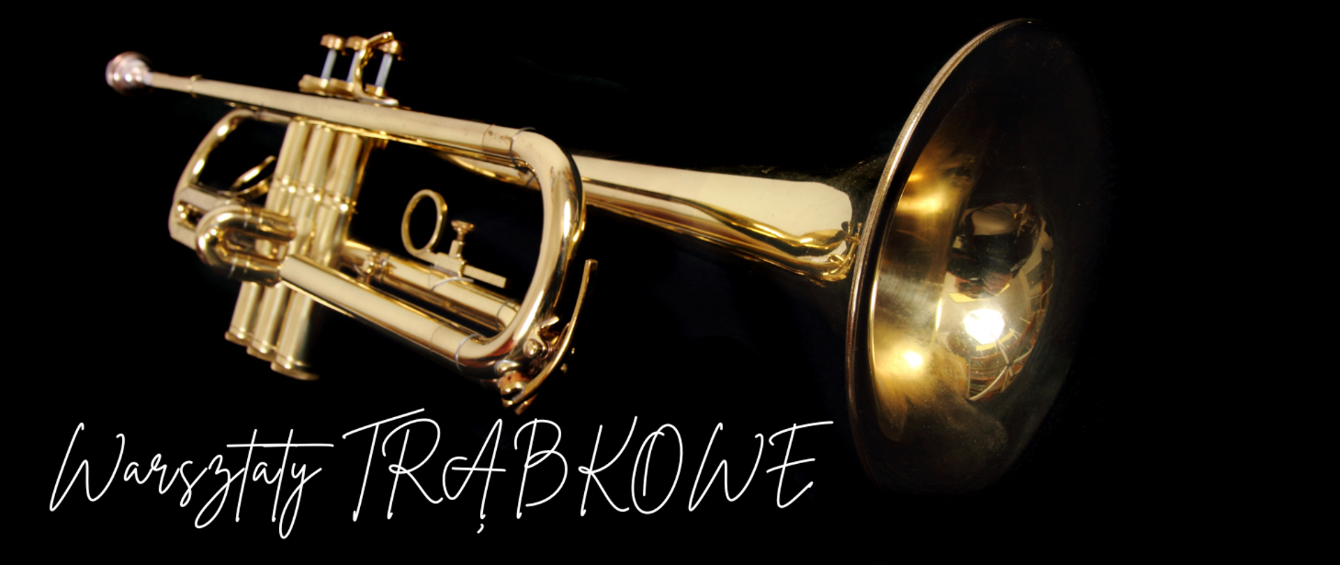 Na zdjęciu widać złotą trąbkę na czarnym tle. Instrument jest dobrze oświetlony, dzięki czemu błyszczy i podkreśla swoje metaliczne wykończenie. Po lewej stronie znajduje się napis w stylu odręcznym: „Warsztaty TRĄBKOWE”. Całość ma elegancki i muzyczny charakter.