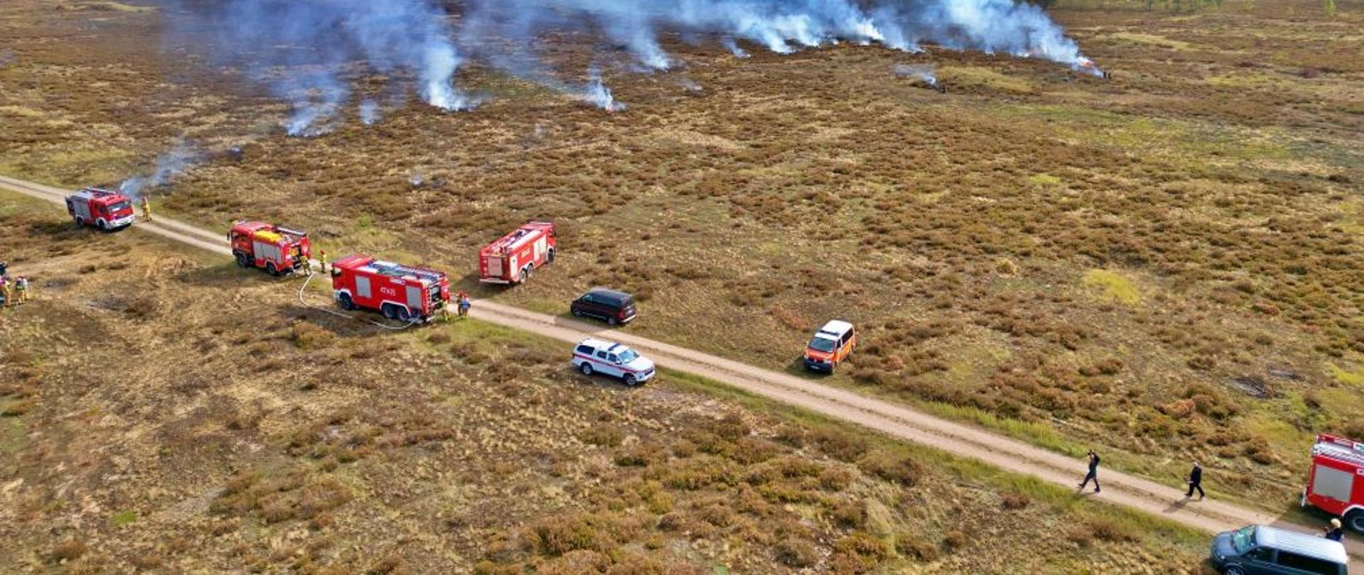 Widok na miejsce ćwiczeń. Zdjęcie wykonane z drona. W oddali widać palące się trawy.