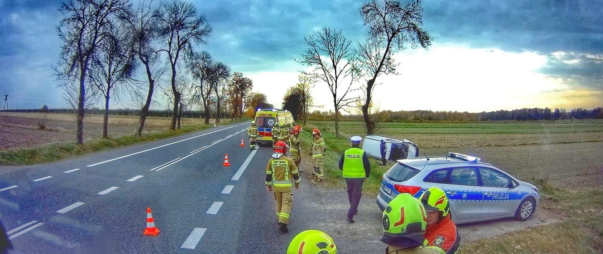 samochód osobowy leży na prawym boku na polu