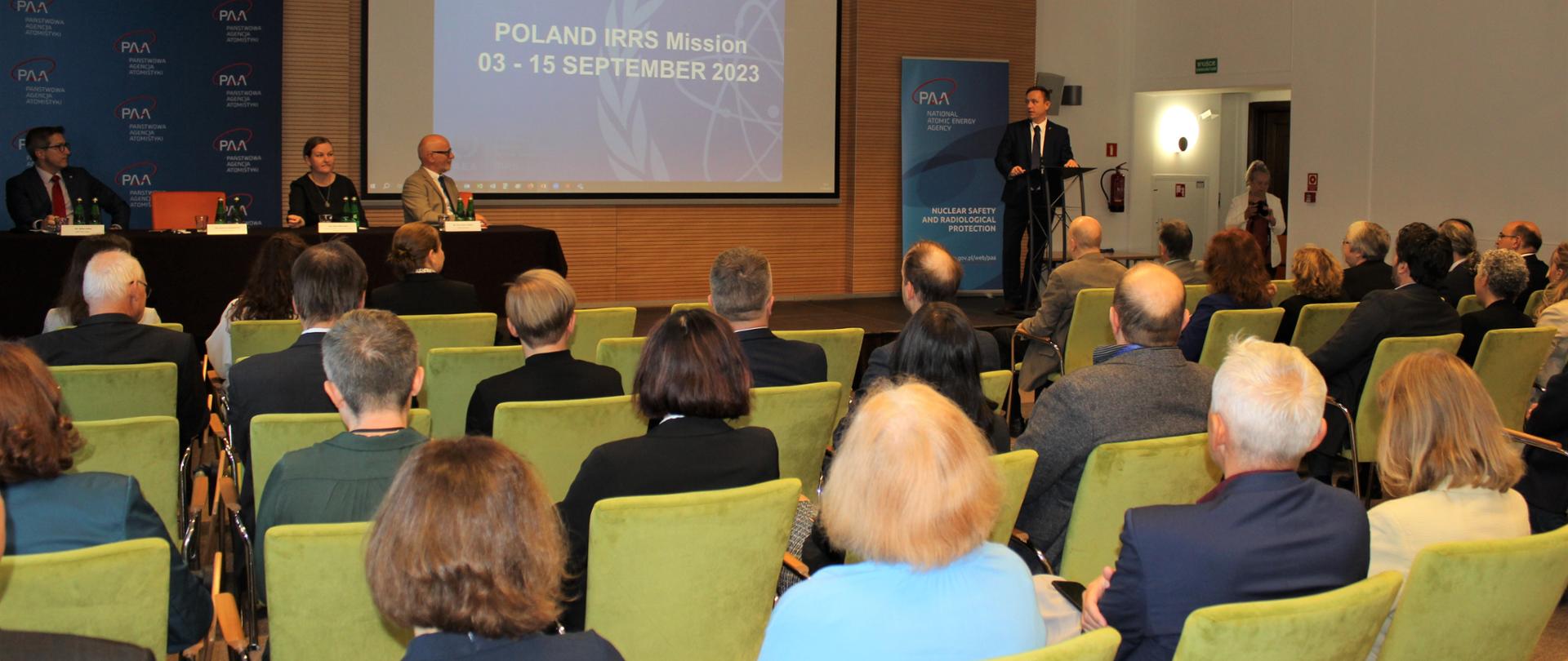 Misja IRRS w Polsce - spotkanie zamknięcia misji. Uczestnicy siedzą na sali plenarnej. Prezes PAA przemawia do zebranych 