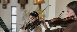 uczennice grające na skrzypcach w kościele