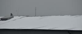 Na zdjęciu widać dach budynku magazynowego znajdujący się na terenie miasta Skarżysko-Kamienna na którym zalega duża warstwa śniegu.