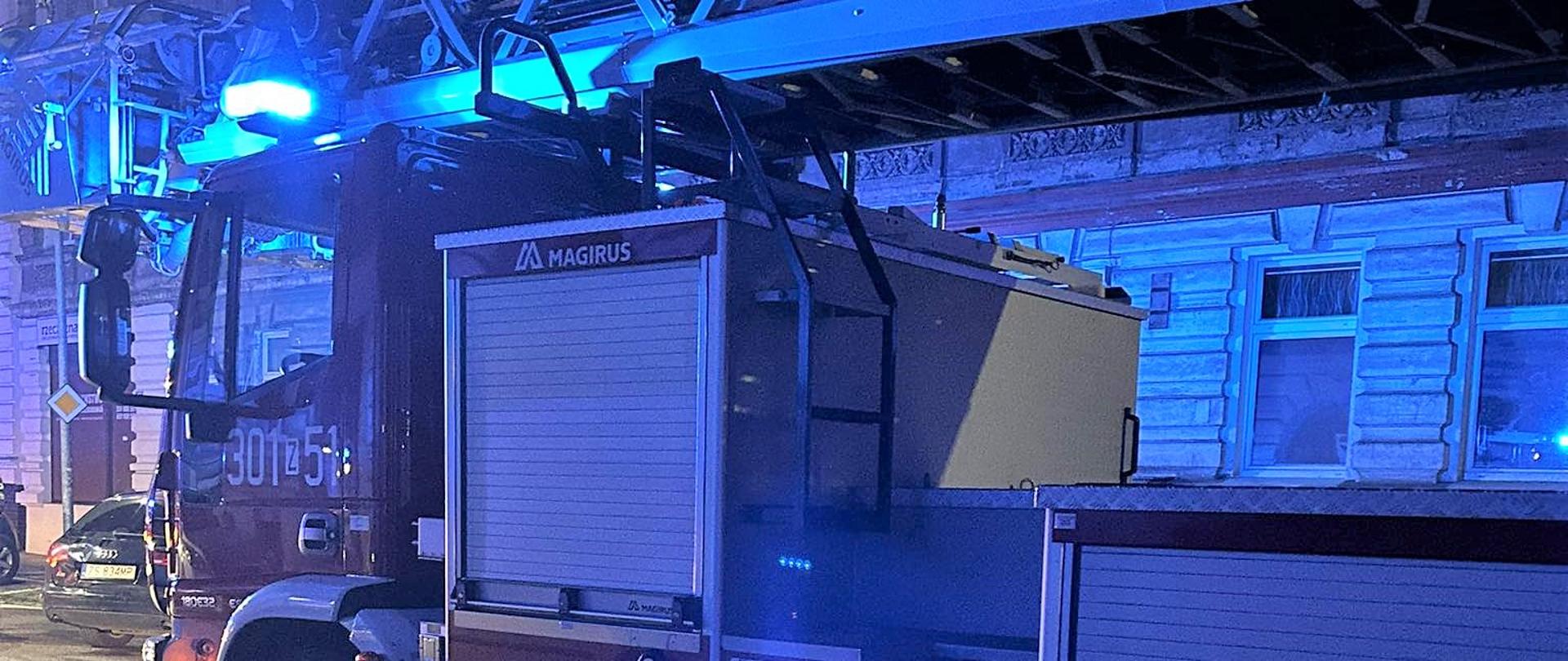 Na pierwszym planie samochód z drabiną mechaniczną na ul. Łokietka w porze nocnej. Za samochodem zabudowa wielorodzinna.
